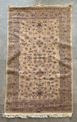 un tapis beige à motifs floraux et franges