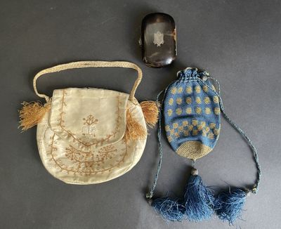two purses and a cell phone on a table