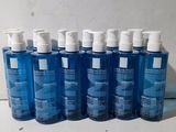 plusieurs bouteilles contenant un liquide bleu posées sur une table blanche