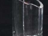 a clear glass vase with a curved design on a black background
