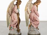 two figurines of angels are sitting on top of a table