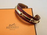 Le bracelet est en cuir et possède un fermoir plaqué or.