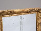 a mirror with a gold frame on the wall