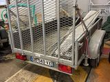 a trailer with a cage on the back of it in a garage