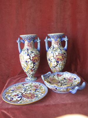 deux vases et une assiette posés sur une nappe rouge