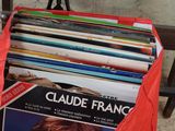 un sac rouge rempli de livres posé par terre