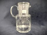 a glass pitcher with a handle and a label on it