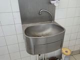 a sink in a public restroom with a trash can