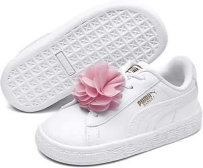 un gros plan sur une paire de chaussures blanches ornées d'une fleur sur la semelle
