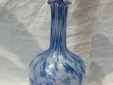 a blue and white glass bottle on a white table
