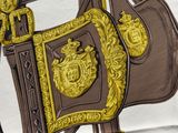 a close up of a horse ' s saddle with a gold decoration on it