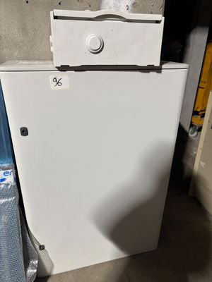 a small white refrigerator in the corner of a room
