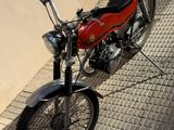a red motorcycle parked on the side of a building