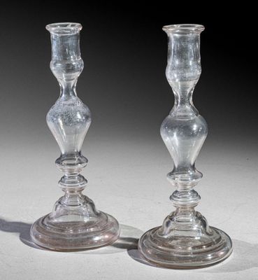pair of clear glass candlesticks sitting on top of a white table