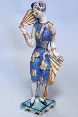 une figurine représentant une femme tenant un éventail et un éventail