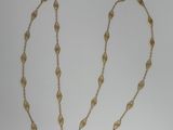 a close up of a gold chain with a leaf design on it