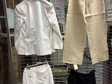 several pairs of pants hanging on a wire rack in a room