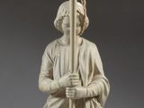 une statue représentant une femme tenant un candélabre, avec un candélabre en arrière-plan