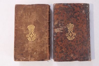 un vieux livre surmonté d'une couronne, à côté d'un autre vieux livre surmonté d'une couronne