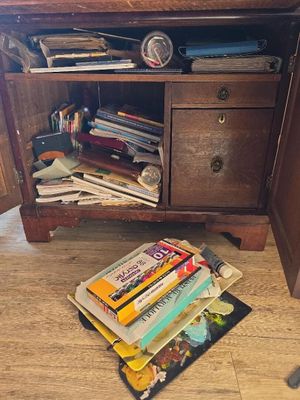 a book on the floor next to a wooden cabinet