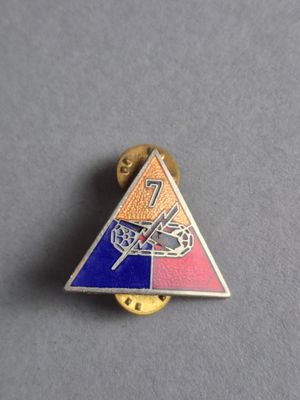 un gros plan d'une petite broche triangulaire ornée d'une libellule