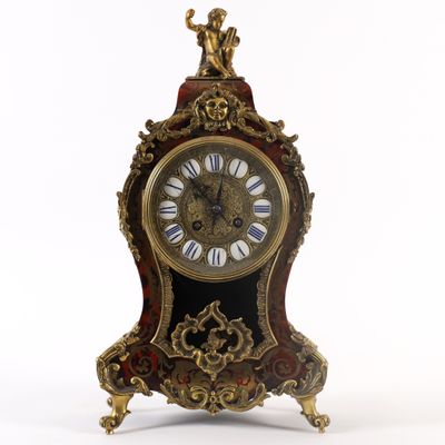 une horloge posée sur un support sur une surface blanche