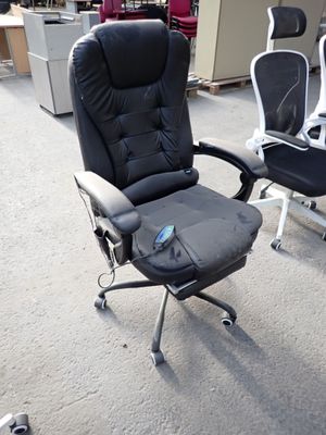 a black office chair with a remote control in the middle of the room