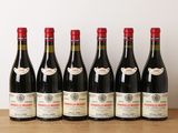 six bouteilles de vin rouge alignées sur une table en bois