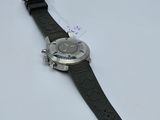 wrist watch on a white surface with a tag attached to it