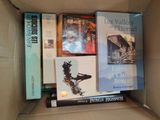 many books in a box that are sitting on top of each other