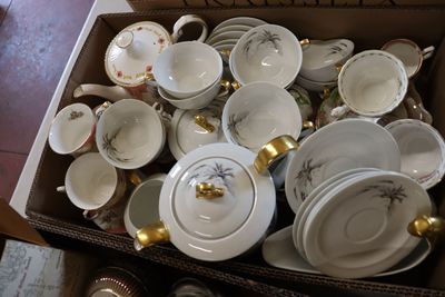 a box full of white and gold china plates and bowls