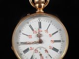 a gold pocket watch with roman numerals on the face