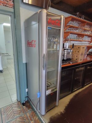 un réfrigérateur qui se trouve dans le coin d'une pièce