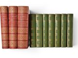 several books are lined up in a row on a white surface