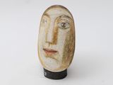 a ceramic sculpture of a man ' s face on a stand