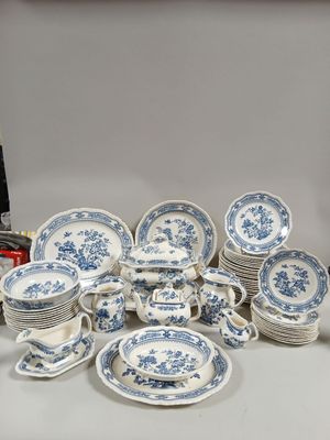 beaucoup d'assiettes et de bols bleus et blancs sur la table