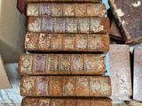 several old books stacked on top of each other on a table