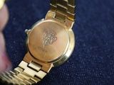 a close up of a person holding a gold watch