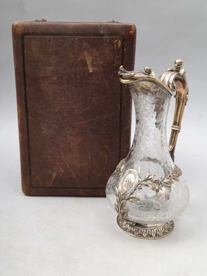 un vase en argent posé à côté d'une boîte marron