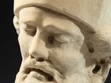 an old statue of a man with a hat on top of his head
