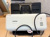 a printer that is connected to a charger on a desk
