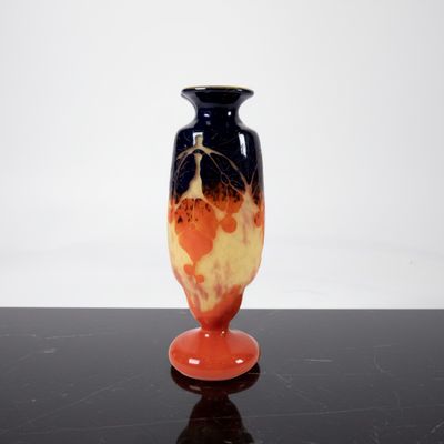 a black and orange vase sitting on a black table