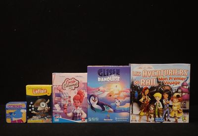 Plusieurs livres pour enfants sont alignés sur une surface noire