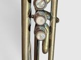 a brass instrument that is sitting on a white surface