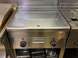 une grande cuisine en inox équipée d'un évier et d'une cuisinière