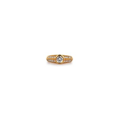 une bague en or jaune sertie d'un diamant blanc