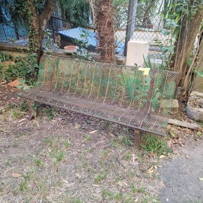un banc en métal posé au milieu d'une cour