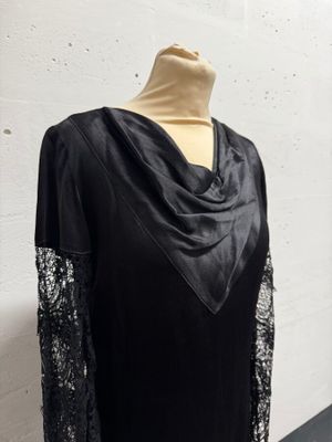 a black dress with a cow neck and lace sleeves on a mannequin mannequin mannequin mannequin mannequin mannequin manne