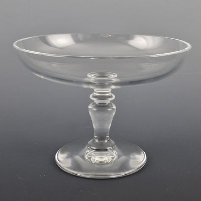 un saladier en verre transparent posé sur une table noire