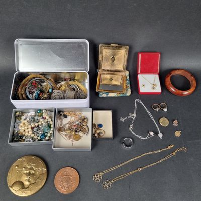 Plusieurs bijoux différents sont disposés dans une boîte posée sur une table